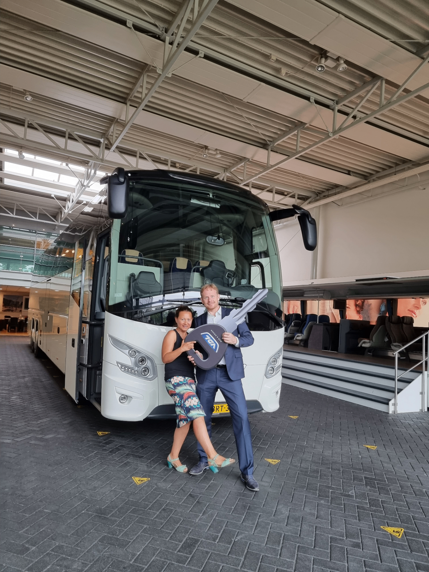 Robbert en Laura bij de sleuteloverdracht van hun nieuwe VDL-touringcar